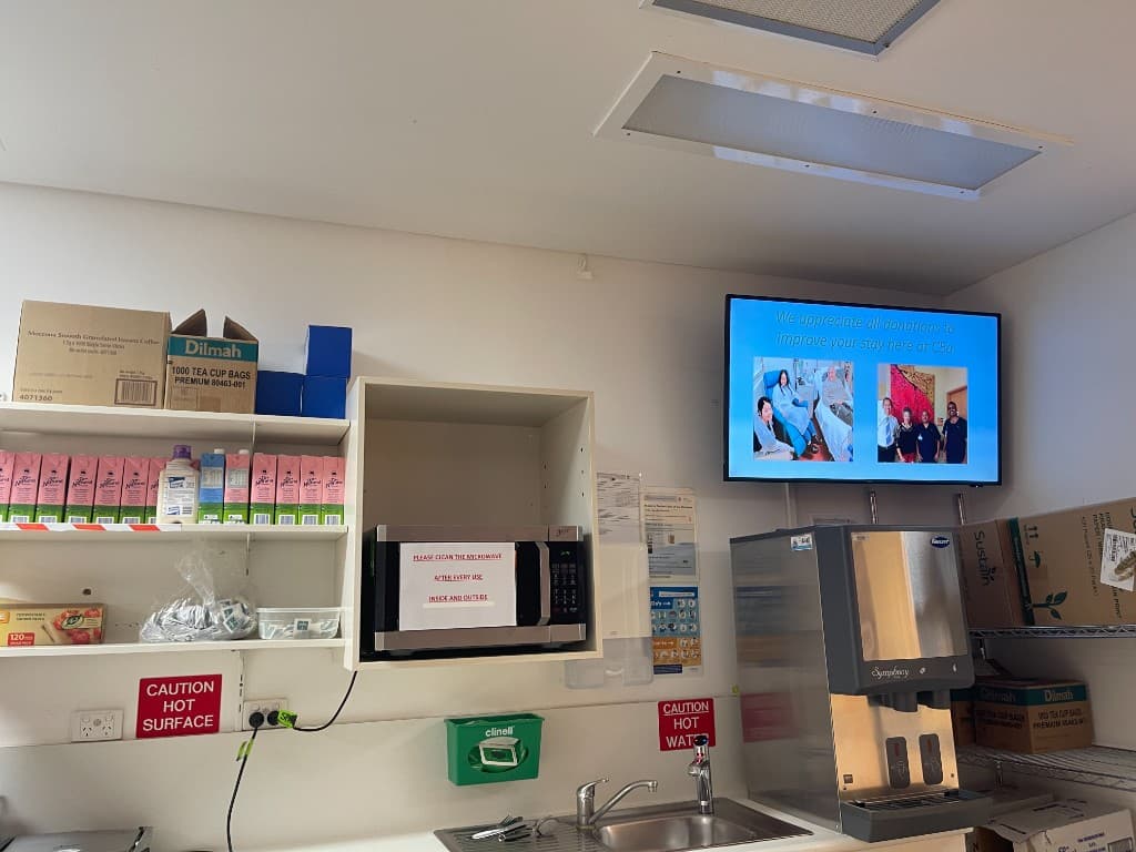 A new educational screen on Ward C5A's kitchen wall, displaying a slide thanking donors for supporting patient care on the ward